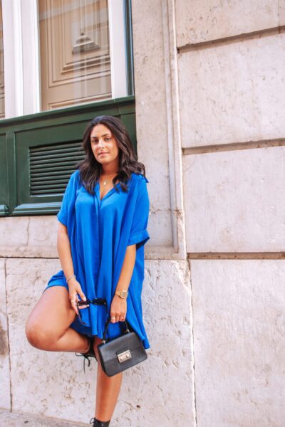 Alfama é um vestido azul escuro estilo camiseiro oversized, o que o torna um modelo confortável. É um vestido curto, fluido e versátil, perfeito para várias ocasiões.