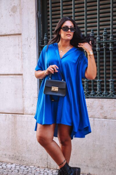 Alfama é um vestido azul escuro estilo camiseiro oversized, o que o torna um modelo confortável. É um vestido curto, fluido e versátil, perfeito para várias ocasiões.