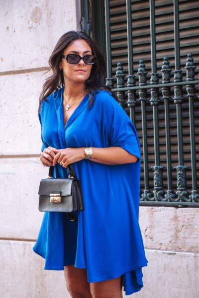 Alfama é um vestido azul escuro estilo camiseiro oversized, o que o torna um modelo confortável. É um vestido curto, fluido e versátil, perfeito para várias ocasiões.