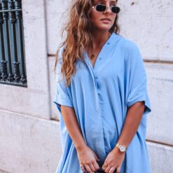 O vestido Alfama Azul é um vestido azul estilo camiseiro oversized, o que o torna um modelo confortável. É um vestido curto, fluido e versátil, perfeito para várias ocasiões.